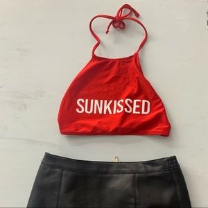 Red crop top with a black leather skirt.